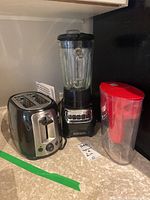 Photo showing the full kitchen lot with the Black and Decker blender, Black and Decker toaster, and Brita water pitcher arranged on countertop.