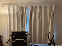 Two cream-colored cotton curtain panels hanging on a rod, covering a window. Measurement approximately 60x50 inches each.