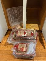 Photo showing multiple ceramic trays stacked and plastic dish rack inside cabinet