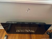 Front and top view of the electric fireplace insert showing the black frame and glass front.