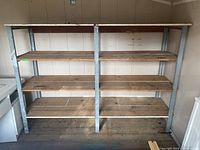 Front view of shelving unit showing six wooden shelves in two columns supported by galvanized steel frame.