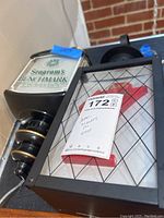 Two Seagrams advertising light wall hangings side by side on black surface with a label identifying lot number. One sign is Seagrams Benchmark Premium Bourbon, the other is Seagrams 7 with wire mesh front.