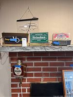 Four beer advertising lights on a fireplace mantel and wall mount, showing full lot content.