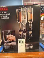 Photo of one Oggi 3 Bottle Revolving Liquor Dispenser box showing product image and label.