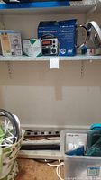 Midland emergency radio in box, indoor spotlight lamp, white power strips on shelf
