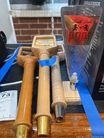 Top view of several wooden beer tap handles and a triangular metal pull handle with Prior label displayed