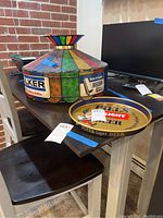 Plastic hanging advertising light with colorful panels and Walker muffler branding, sitting on a table next to the metal tray