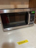 Closed view of the Farberware microwave oven showing stainless steel exterior, digital keypad, and display showing 8:88.