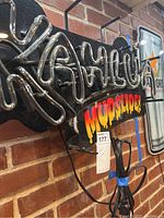 Close-up of the front of the neon sign showing the 'Kahlua' neon tubing and the colorful 'Mudslide!' panel beneath.
