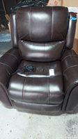 Front view of dark brown electric recliner showing overall shape and condition.
