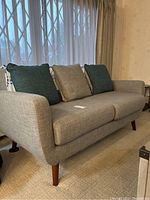 Front view of entire sofa showing seat cushions, arms and included pillows