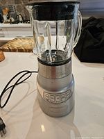 Full view of the Cuisinart blender showing the glass jar, lid, and silver base with control buttons visible on front.