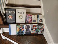 Photo of all 10 hardcover books arranged on wooden steps, showing titles, authors, and some cover art.