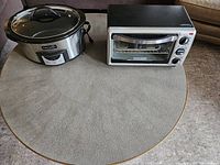 Photo showing both Crockpot slow cooker and Black & Decker toaster oven on a table.