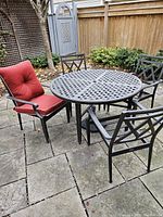 Six chairs arranged around round table with one chair shown with cushion