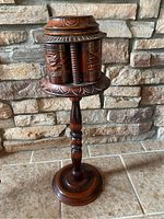Full view of antique wooden pipe stand with carved rotating top and pedestal base