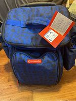 Front view showing fabric pattern, carrying handle, and Outbound logo on front pouch.