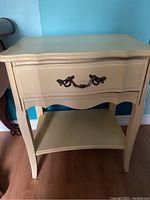 Front view of French Provincial night stand showing drawer and lower shelf
