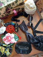Photo of assorted hair bows, artificial flowers, sunglasses, and other accessories arranged on a wooden surface.