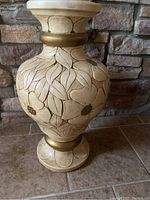 Full view of the large cream vase showing carved floral and leaf designs with gold accents and scratches.