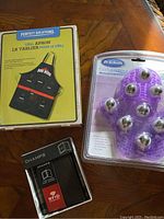 View of all three items: BBQ apron in box, Dr. Scholl's massage expressor in packaging, Champs RFID wallet in box.