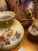 Close-up of one glass lamp shade showing floral design and ruffled edge