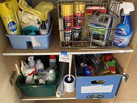 Shelf with blue caddy holding cloths and cleaning supplies, metal basket with various spray bottles and cans including Pledge, WD-40, Clorox bleach cleaner