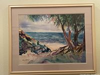 Framed watercolor coastal landscape scene with trees and ocean, signed by artist Carli Oliver in bottom left corner.