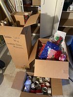 Three boxes containing assorted gift wrap supplies in a storage area.