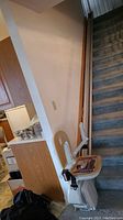Stairlift chair and track installed on straight staircase