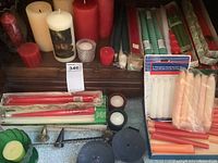 Candles in drawers with tags showing variety including tapers, pillars, votives, and emergency sets.