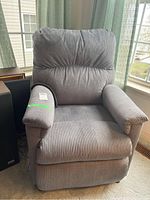 Front view of gray recliner showing overall upholstery and cushion condition
