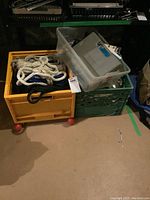 Plastic crates containing several ropes of different colors and thicknesses, along with storage containers on top.