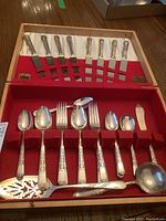 Full view of flatware set in canteen displaying knives, forks, spoons, and various serving pieces with Tudor pattern handles.
