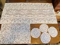 Full view of table runner at top, one place mat and four doilies arranged below