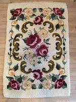 Full view of the hand hooked floral rug showing overall design and condition.