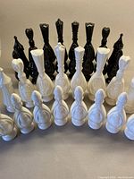 Front-facing view of black and white ceramic chess pieces arranged in rows.
