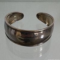 Front view of sterling silver cuff, showing width and polished surface with visible wear and patina.
