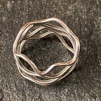 Top view of a sterling silver ring with four wavy bands arranged in a circular layered design.