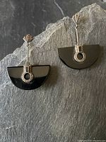 Pair of vintage sterling silver drop earrings each with black onyx half-moon and marcasite stone accents visible on a gray background.