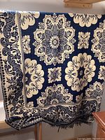 Large navy and cream floral medallion patterned textile draped over railing