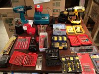 Overhead view of two drills, chargers, batteries, and assorted bit sets