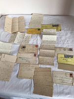 Display of various handwritten letters and envelopes laid out on fabric background