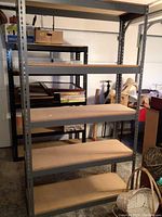 Front view of one metal shelving unit showing five wide shelves, metal frame with perforated posts, and beige wood boards for shelves.