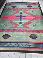 Full view of the Southwestern area rug showing overall pattern and color scheme on wooden floor.