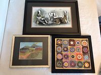 Photo showing all three framed mixed media artworks together on a white surface: a horizontal rectangular piece with black frame, a square piece with circles in black frame, and a smaller rectangular landscape in light wooden frame.