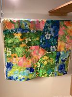 Small floral patchwork quilt with varied bright colors and multiple flower patterns in a patchwork arrangement