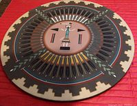 Full view of the circular Navajo sandpainting wall hanging with detailed feathers and geometric border