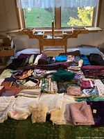 Expanded wooden sewing box open with multiple tiers and fabrics laid out in front