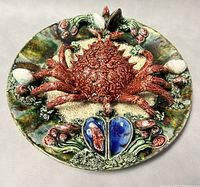 Top front angle view showing the red crab centerpiece and surrounding seafood design on the ceramic plate.